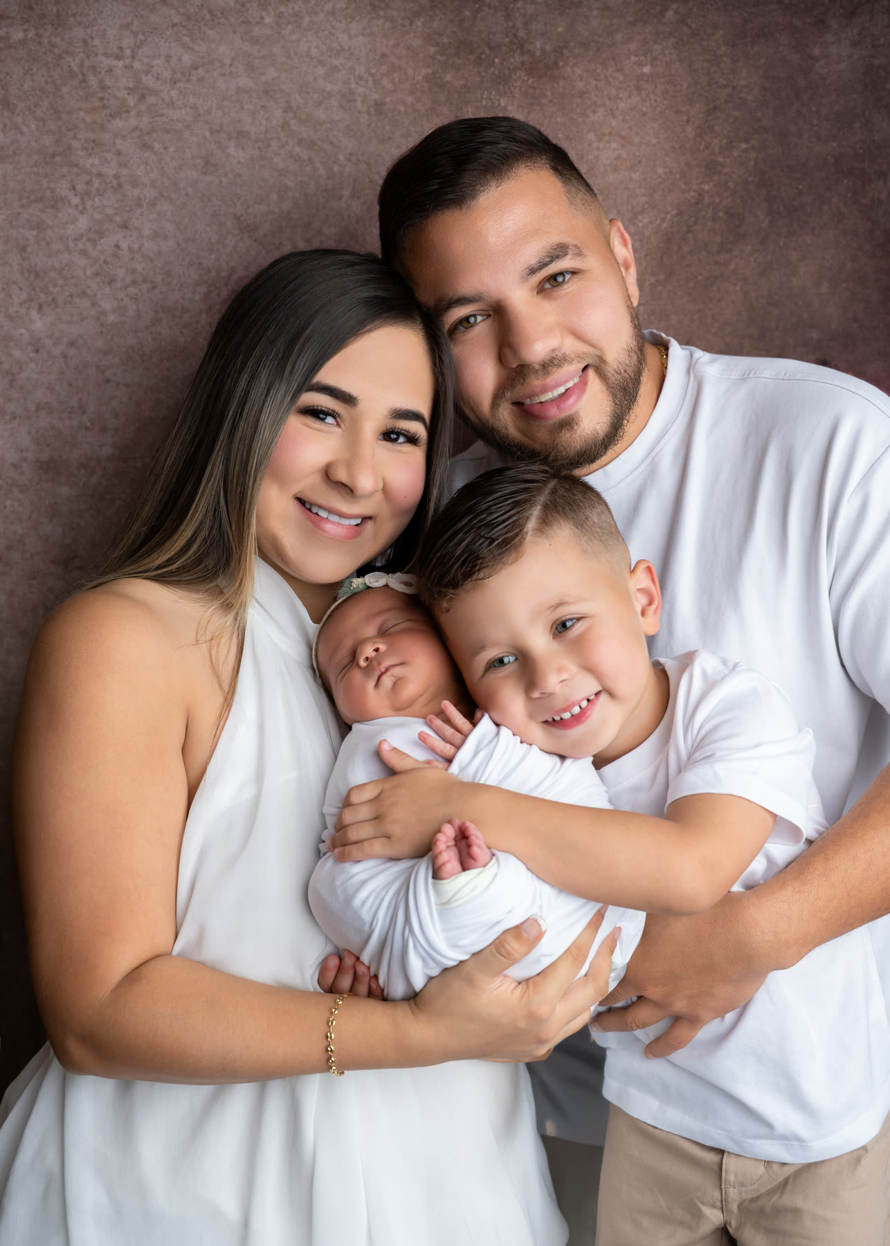 Parents and big brother holding the new baby