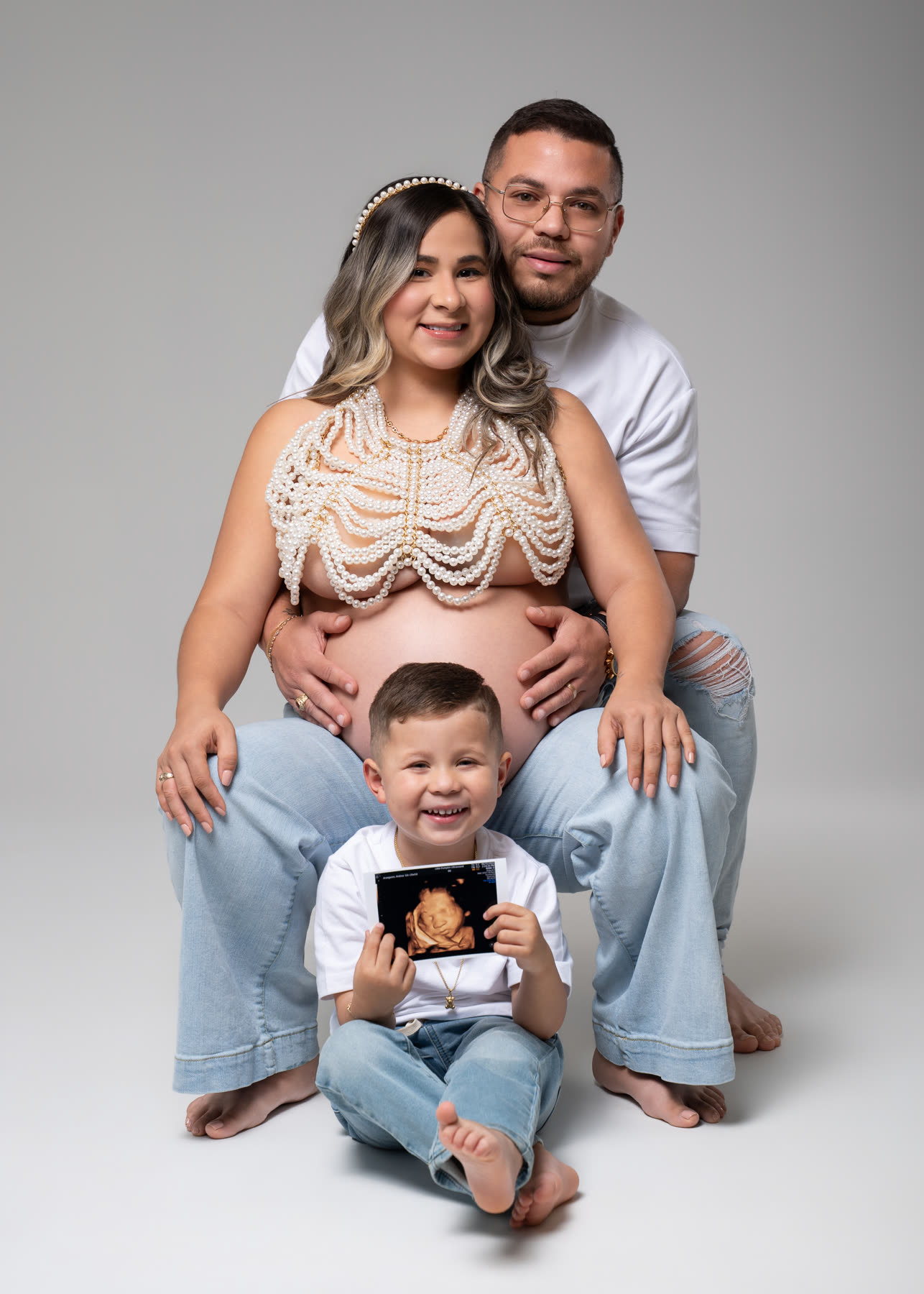 Expecting parents with their son holding the sonogram