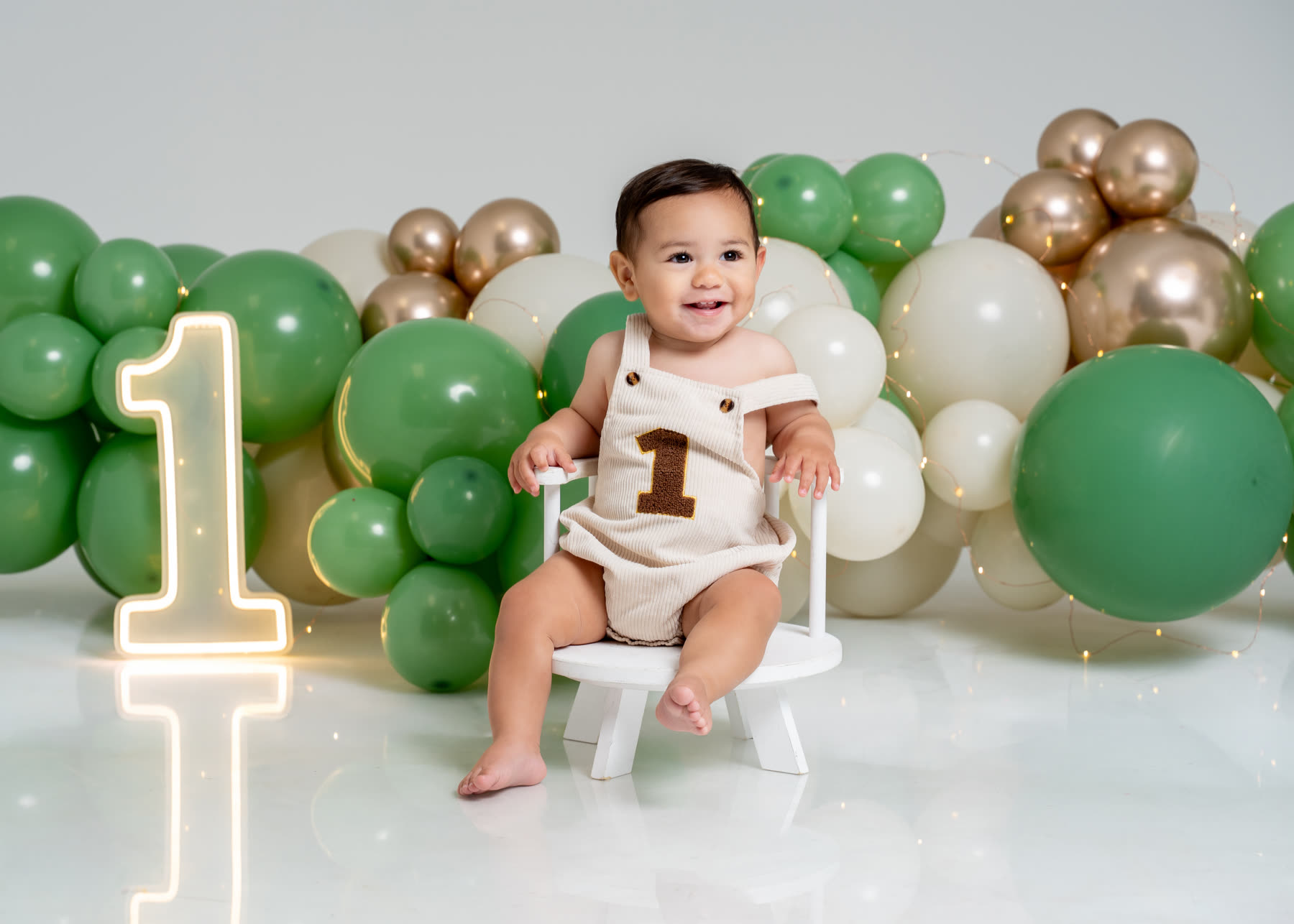 First birthday portrait with green and gold balloons