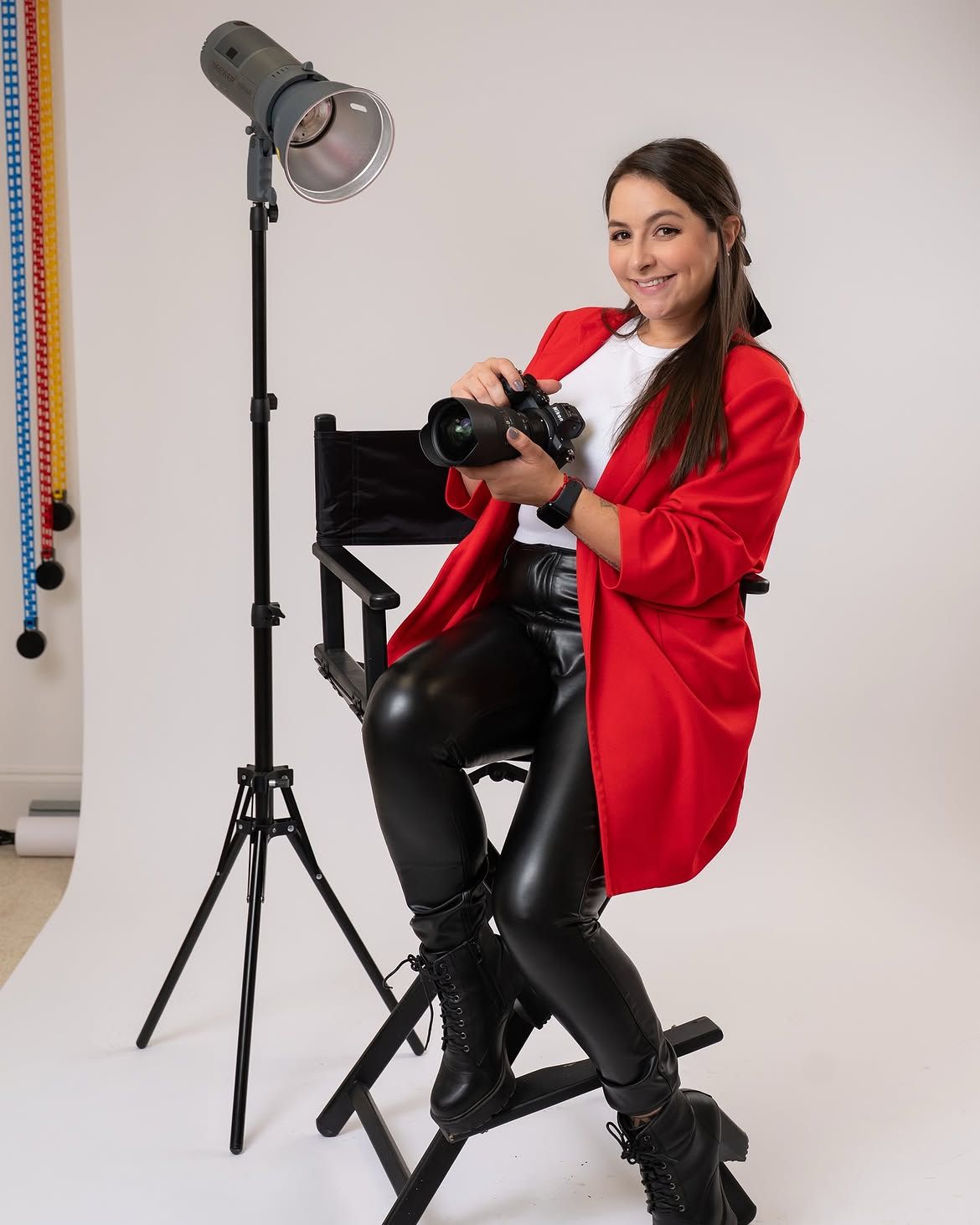 Luz Reyes, photographer, seated with her camera in the studio