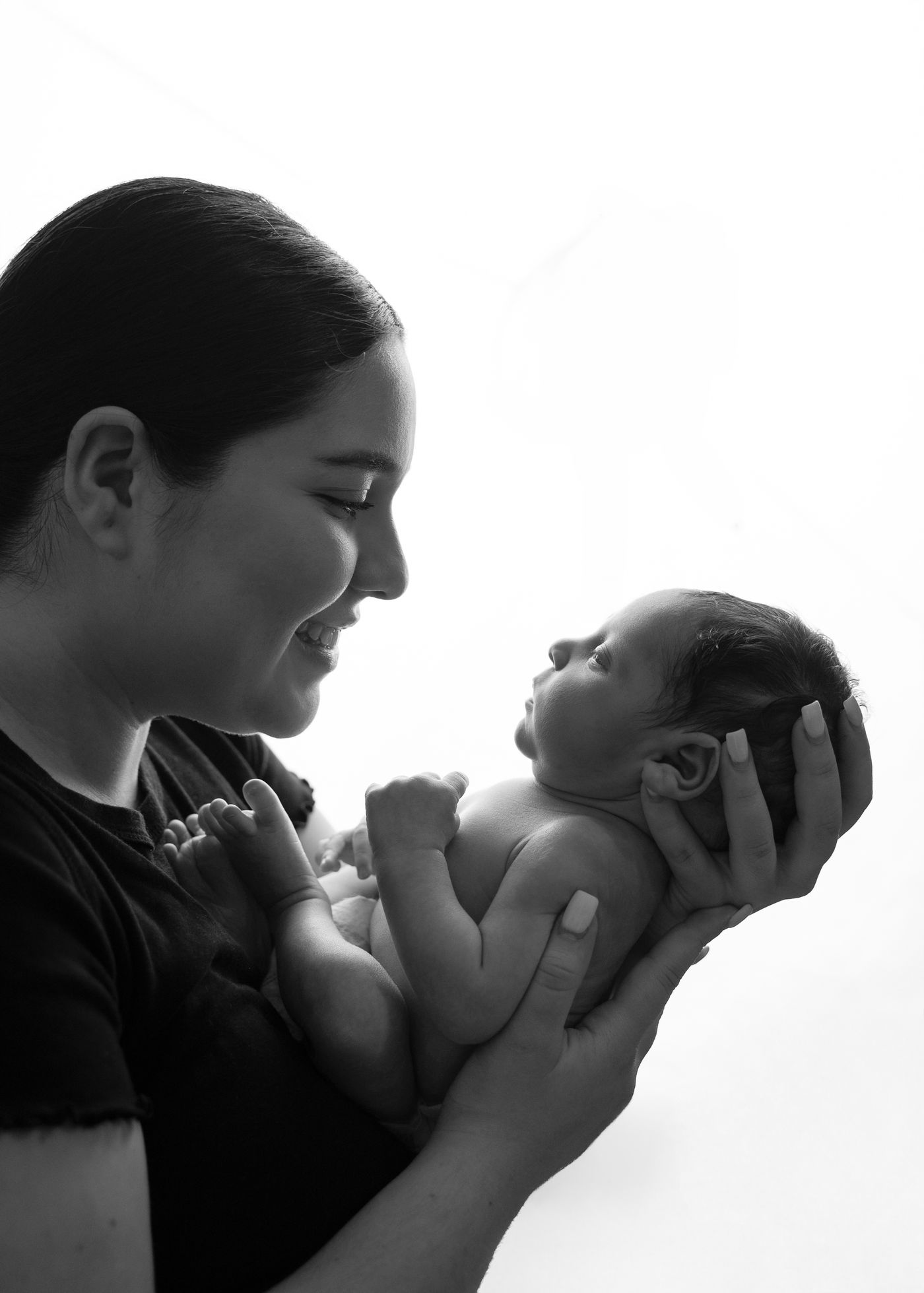 Mother smiling at her newborn in black and white