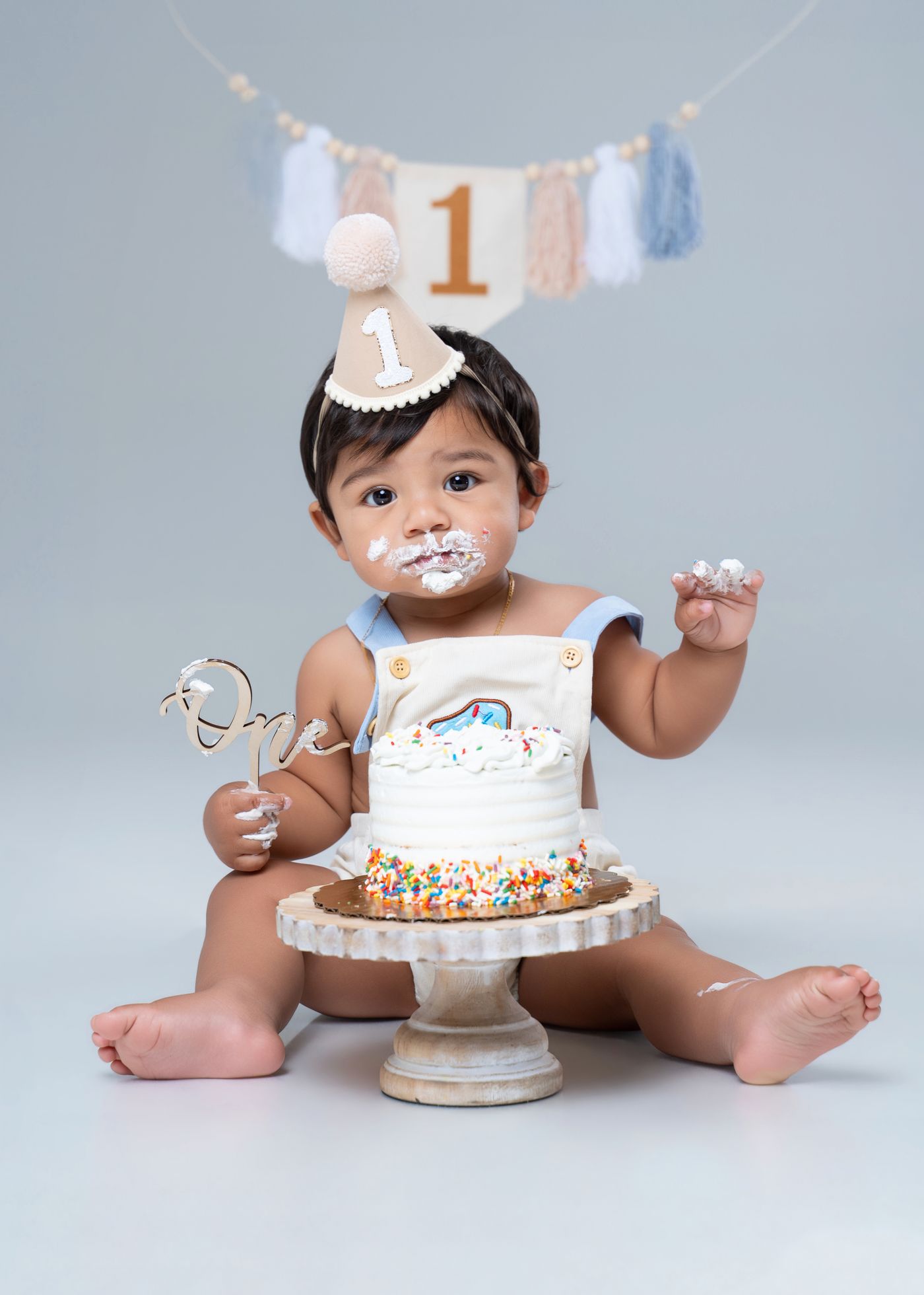 One-year-old smash cake with frosting on their face